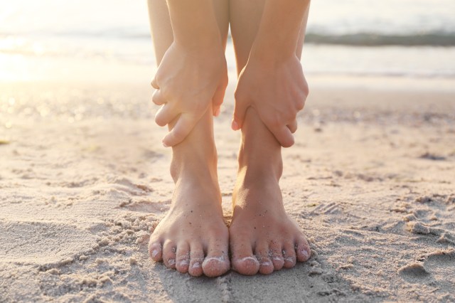 Close up view on woman hands and legs during doing yoga